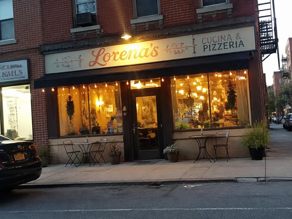 A small neighborhood restaurant storefront lit up at dusk